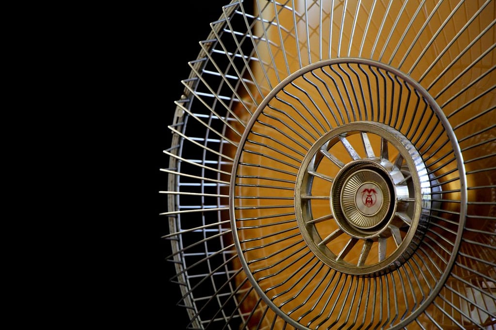 A detailed close-up of a vintage electric fan showcasing its intricate metal blades and design.